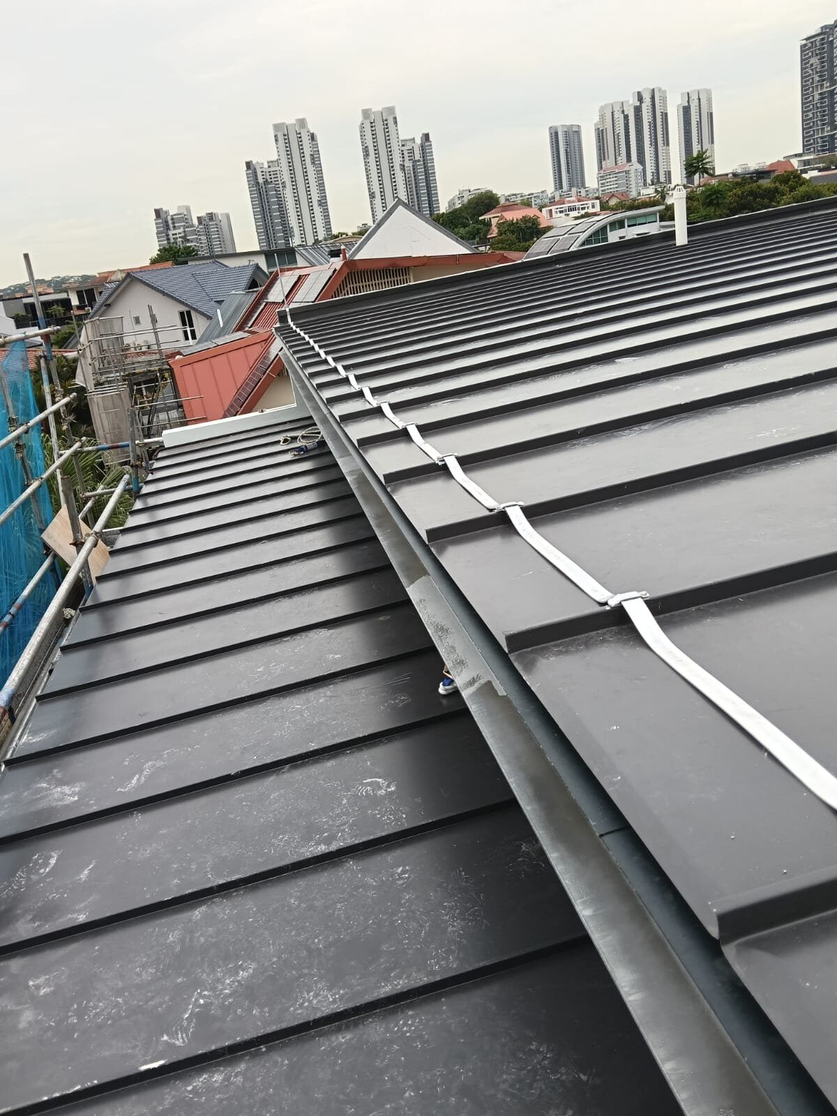Down conductor clamped along a standing-seam metal roof